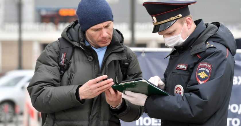 Сотрудник полиции проверяет цифровой пропуск у мужчины в Москве. Михаил Воскресенский / РИА Новости