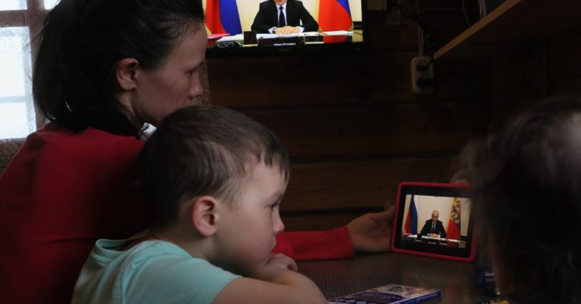 Женщина с детьми смотрит трансляцию совещания президента РФ Владимира Путина с главами регионов по борьбе с распространением коронавируса в России. Антон Денисов / РИА Новости