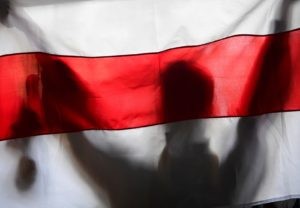 Участник акции протеста держит неофициальный флаг Белоруссии у здания Минского государственного лингвистического университета. Алексей Майшев / РИА Новости