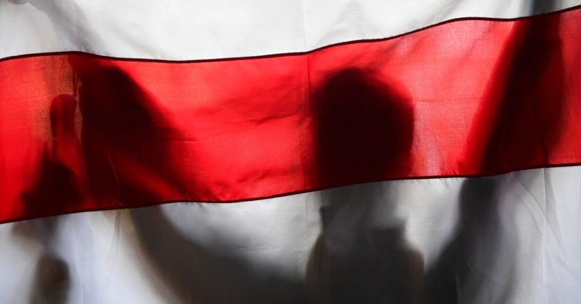 Участник акции протеста держит неофициальный флаг Белоруссии у здания Минского государственного лингвистического университета. Алексей Майшев / РИА Новости
