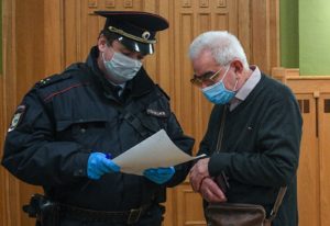 Сотрудник полиции вручает пожилому мужчине в холле театра "Ленком" памятку об ограничениях из-за коронавируса. В Москве из-за роста числа зараженных коронавирусом пожилым людям рекомендовано оставаться дома. Евгений Одиноков / РИА Новости
