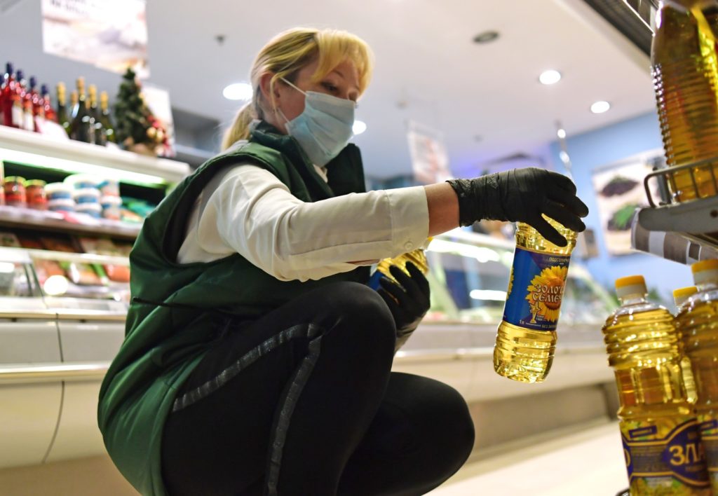 Продавец расставляет бутылки с растительным маслом на полке магазина. Накануне обеспокоенность ростом цен на базовые продукты выразил президент Владимир Путин. Власти рекомендовали бизнесу придерживаться определенного уровня розничных цен на подсолнечное масло и сахар. Алексей Майшев / РИА Новости
