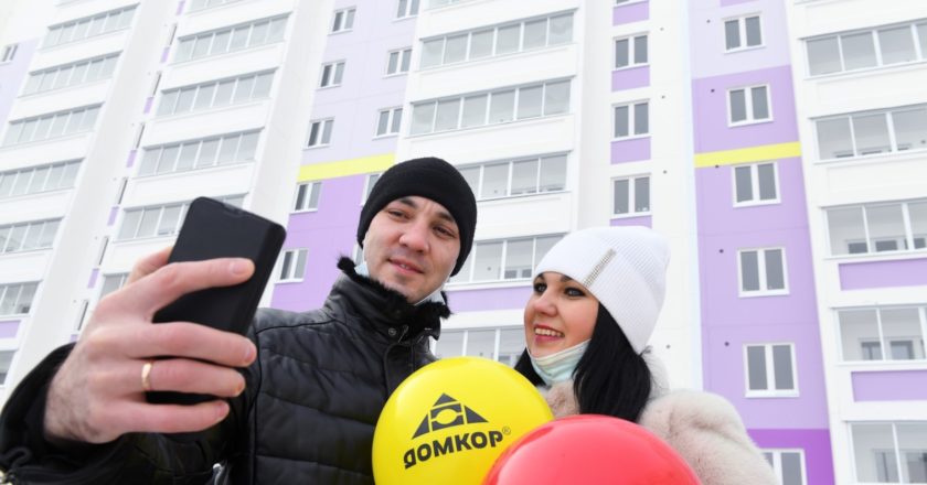 Новоселы фотографируются на фоне нового дома, построенного по программе социальной ипотеки в Набережных Челнах. Квартиры в новом доме получили бюджетники, многодетные и молодые семьи и 92 семьи медицинских работников. Максим Богодвид / РИА Новости