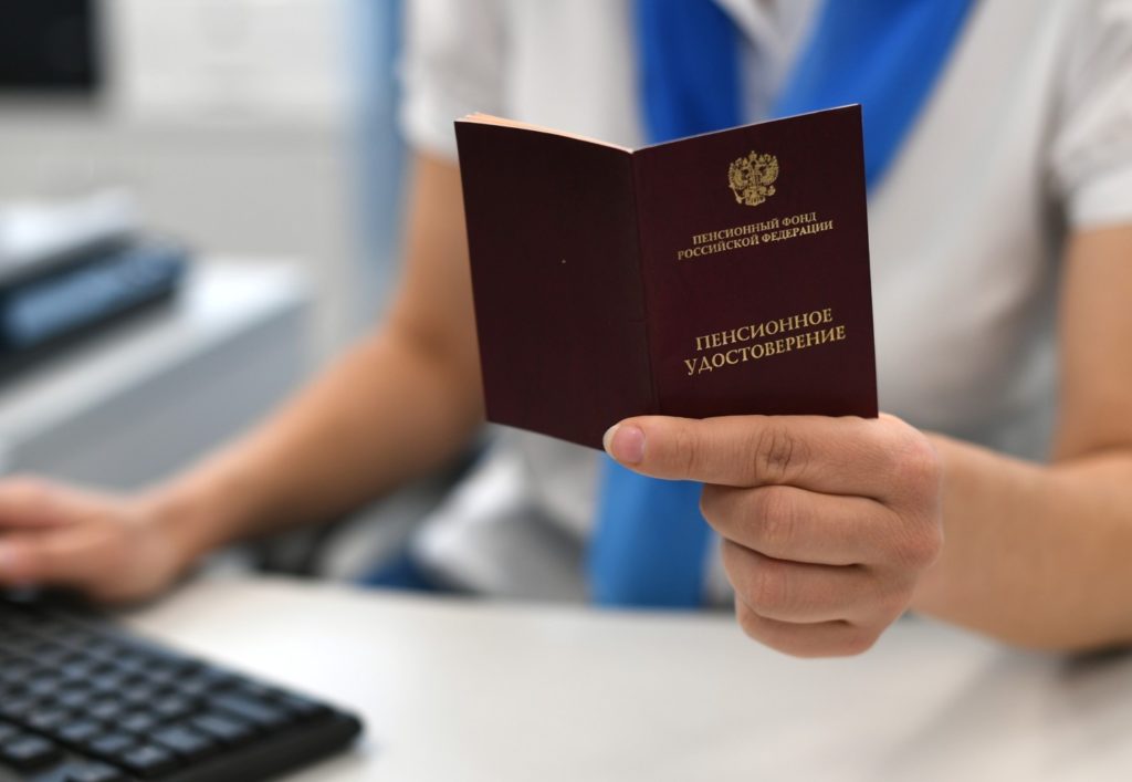 Сотрудник ПФР держит в руках пенсионное удостоверение. Максим Блинов / РИА Новости