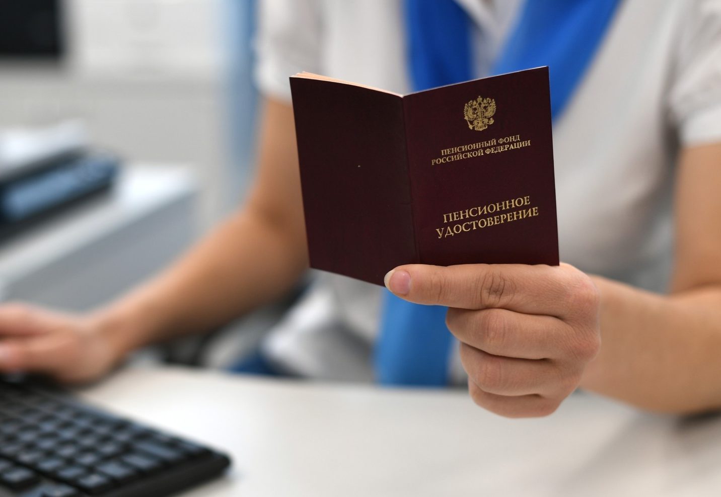 Сотрудник ПФР держит в руках пенсионное удостоверение. Максим Блинов / РИА Новости