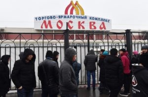 Люди стоят у ограды территории торгово-ярмарочного комплекса "Москва". В ТЦ "Москва" сотрудники полиции и ФМС проводят профилактические проверки. Михаил Воскресенский / РИА Новости