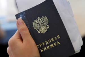 Трудовая книжка в руке у посетителя ярмарки вакансий. Максим Богодвид / РИА Новости