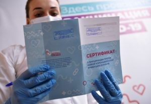 Медицинский работник держит в руках сертификат о вакцинации в мобильном пункте вакцинации от COVID-19 в торговом центре "Арена Плаза" в Москве. Евгений Биятов / РИА Новости