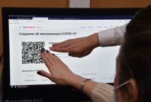 Сотрудник МФЦ показывает мужчине, как распечатать бумажный QR-код в многофункциональном центре госуслуг "Мои документы" в Москве. Алексей Куденко / РИА Новости