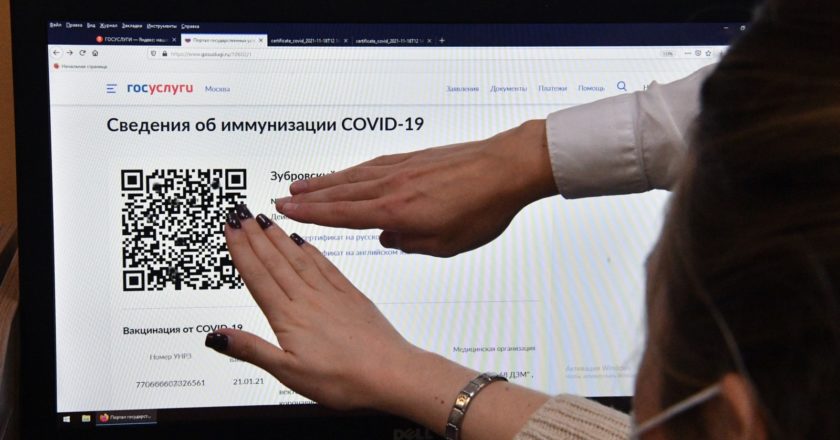 Сотрудник МФЦ показывает мужчине, как распечатать бумажный QR-код в многофункциональном центре госуслуг "Мои документы" в Москве. Алексей Куденко / РИА Новости