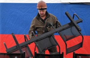 Рабочий шахты "Листвяжная" в городе Белово помогает разбирать палаточный лагерь сотрудникам МЧС РФ. На шахте "Листвяжная" утром 25 ноября произошел пожар. В момент задымления там находились 285 человек. Александр Кряжев / РИА Новости