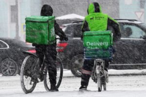 Курьеры службы доставки Delivery Club на одной из улиц во время снегопада в Москве. Кирилл Каллиников / РИА Новости